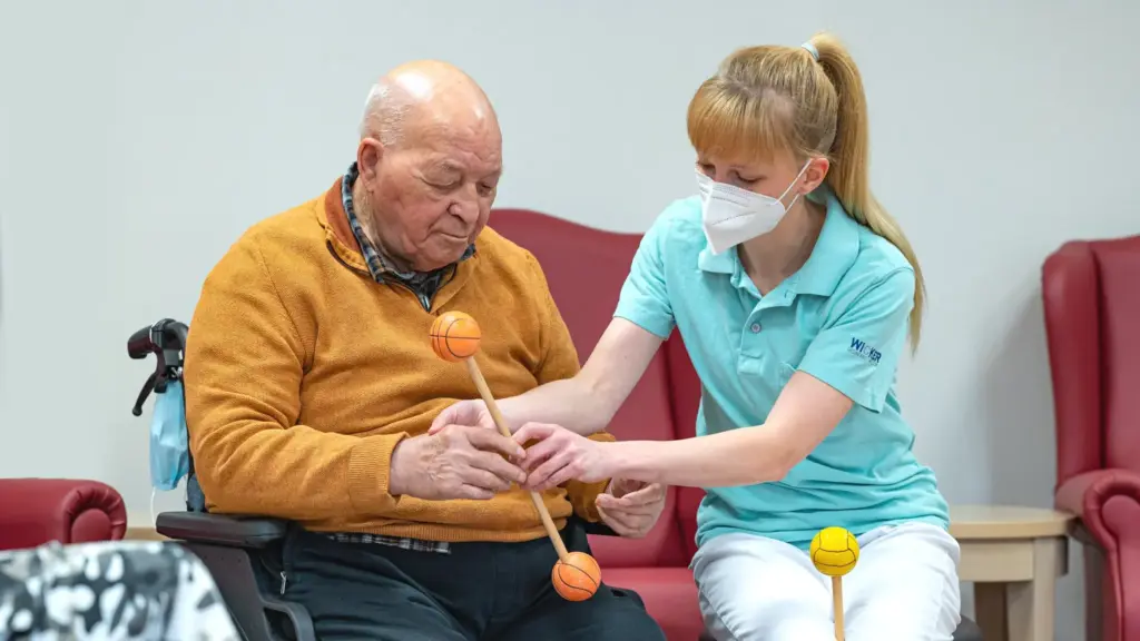 Social Media Pflegeheim Social Media Pflegeheim: Betreuungskraft bei Bewegungsübung mit einem Senior